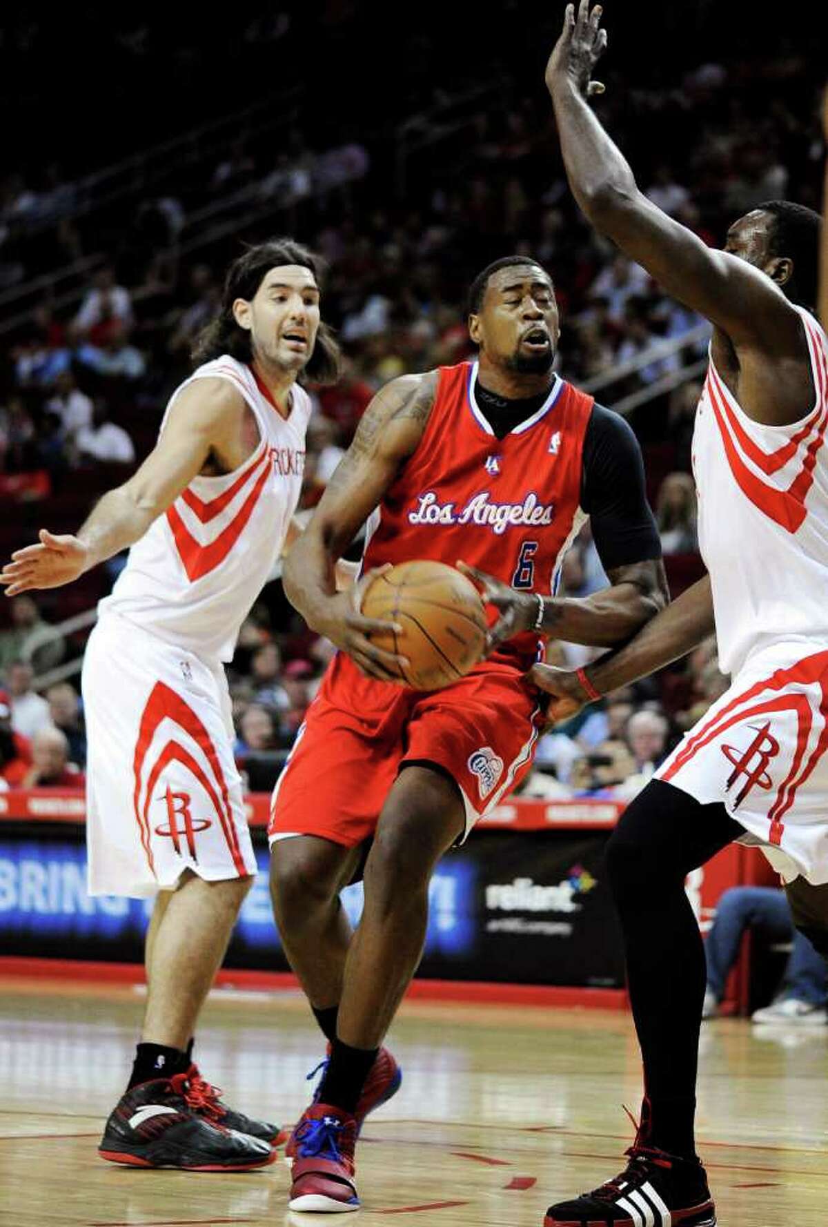 Los Angeles Clippers' DeAndre Jordan (6) drives to the basket between Houston Rockets' Luis Scola, left, and Samuel Dalembert, right, in the first half of an NBA basketball game, Sunday, March 4, 2012, in Houston. (AP Photo/Pat Sullivan)