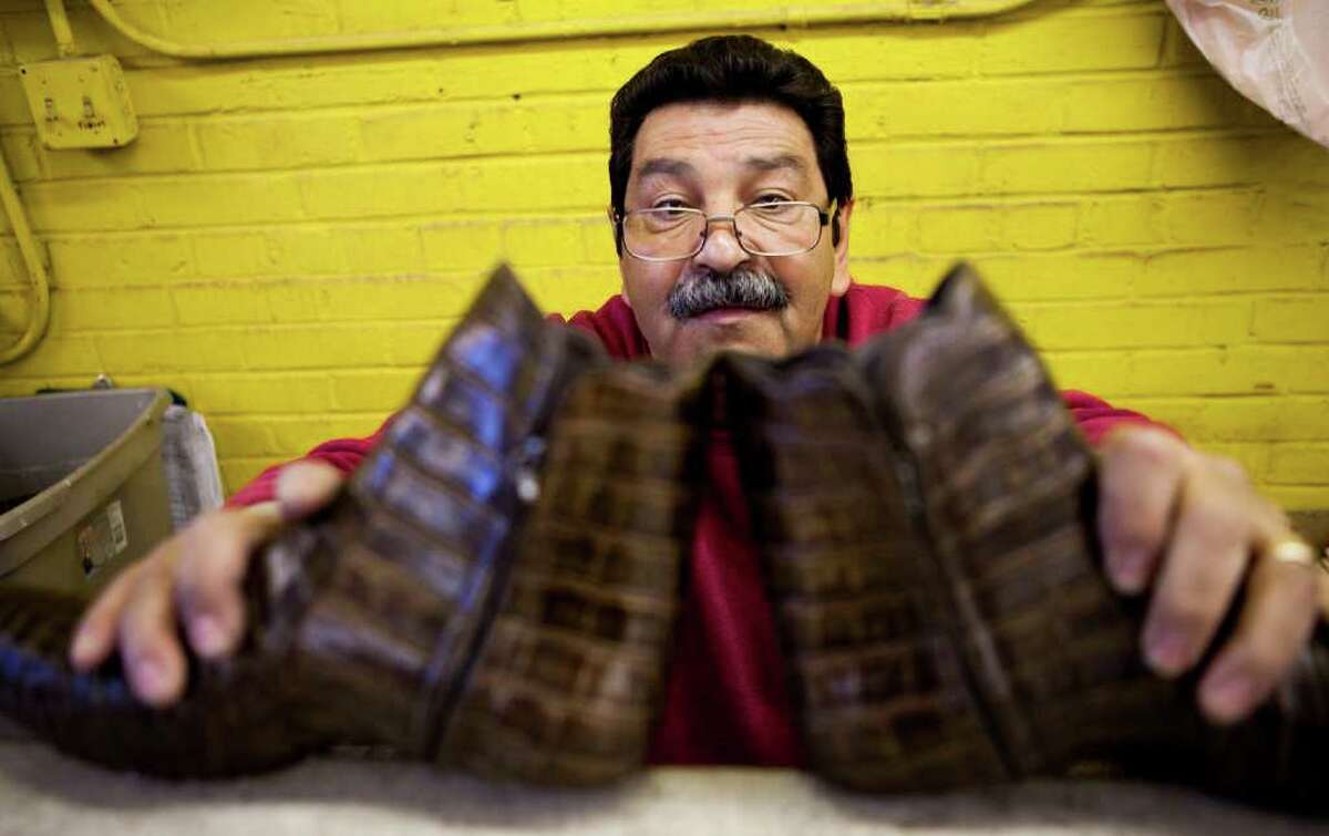Jorge Miscles, of Juarez, Mexico, makes sure a pair of boots he's making are symmetrical Thursday, Feb. 10, 2011, in the Stallion Boots and Leather Goods facility in El Paso.