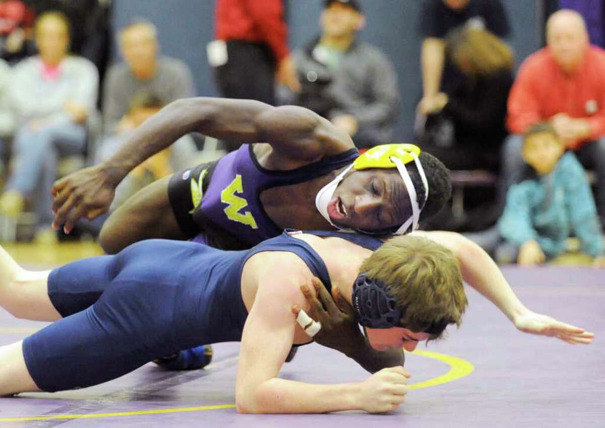 At top, Westhill wrestler Pascal Medor, 113 pounds, during his win over Walter Wingrow, bottom, of Wilton High School, in wrestling match between Westhill High School and Wilton High School at Westhill High School in Stamford, Thursday night, Dec. 22, 2011.