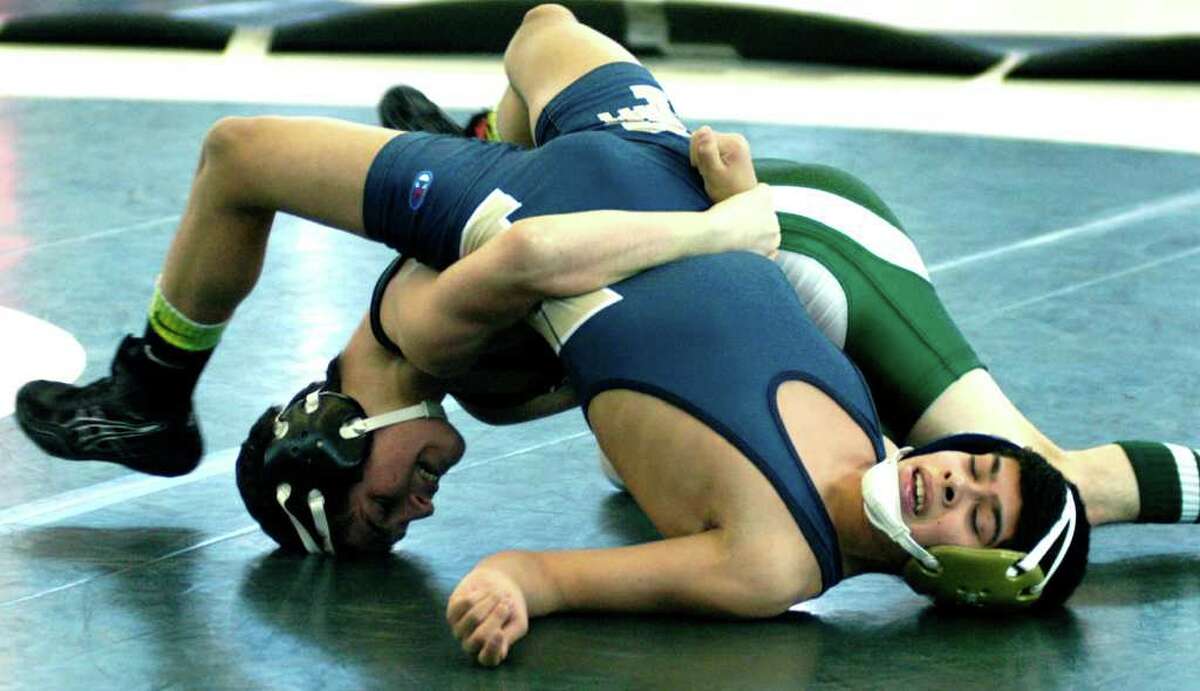 SPECTRUM/Halim Bourjeli, left, of the Green Wave temporarily has Timothy Orrell of Farmington in jeopardy during their 106-pound wrestleback match as New Milford High School wrestling competes Feb. 25, 2012 in the state open tournament at the Floyd Little Athletic Center in New Haven.