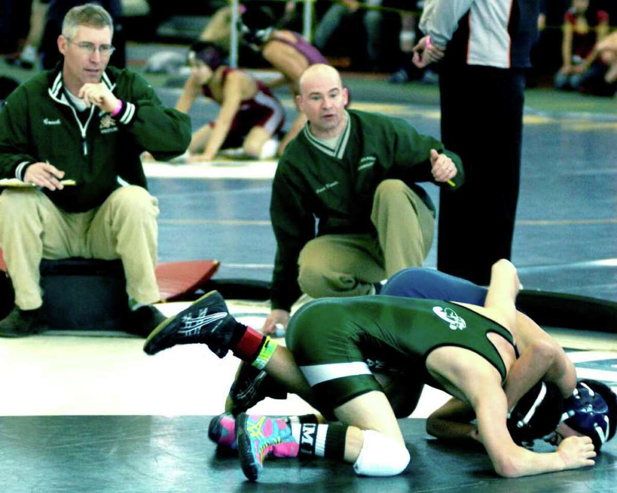 SPECTRUM/Coaches Chris Piel, left, and Daryl Daniels get involved in the match as Halim Bourjeli, foreground, of the Green Wave duels Timothy Orrell of Farmington in a 106-pound wrestleback match as New Milford High School wrestling competes Feb. 25, 2012 in the state open tournament at the Floyd Little Athletic Center in New Haven.