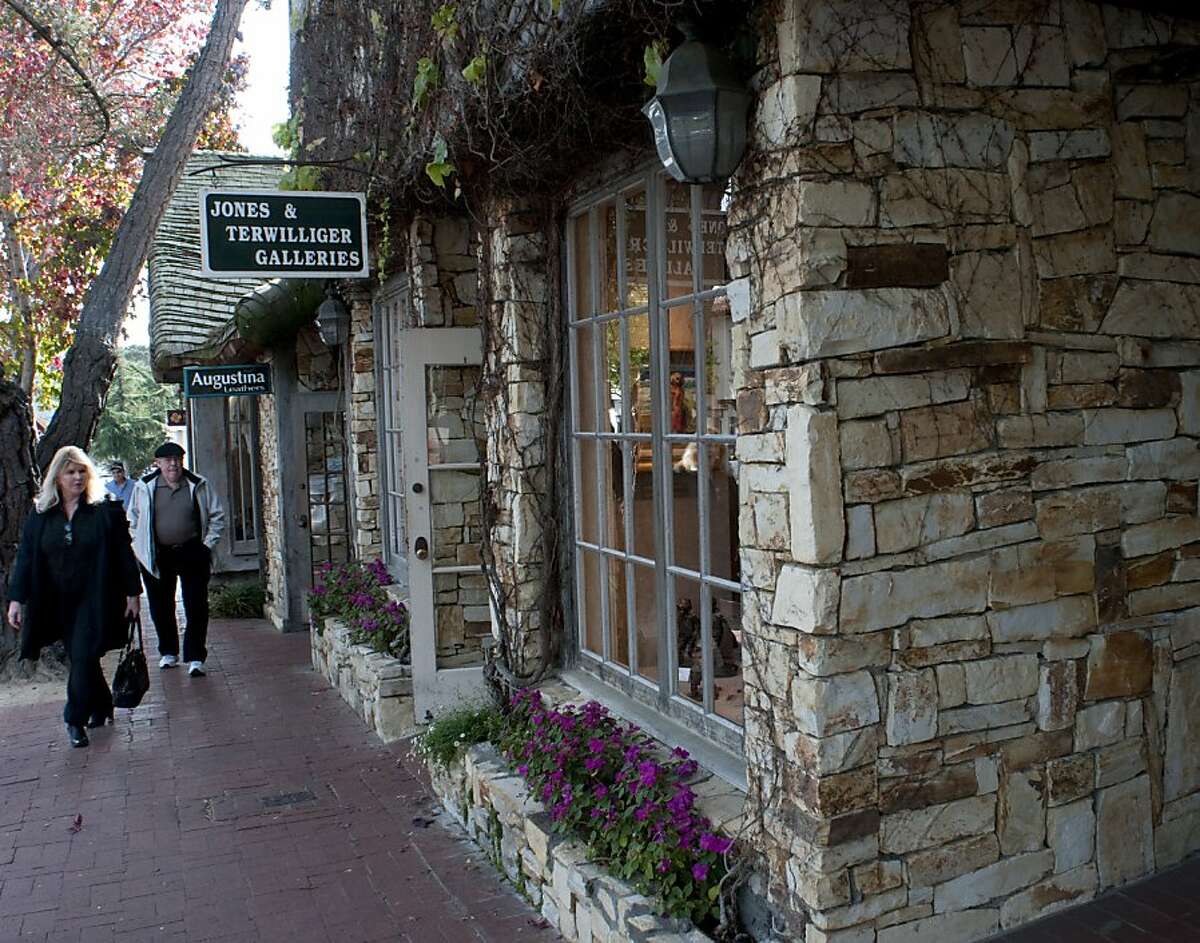 People walk past the Jones & Terwilliger Galleries located on San Antonio between 5th and 6th Avenue in Carmel-by-the-Sea, Calif.