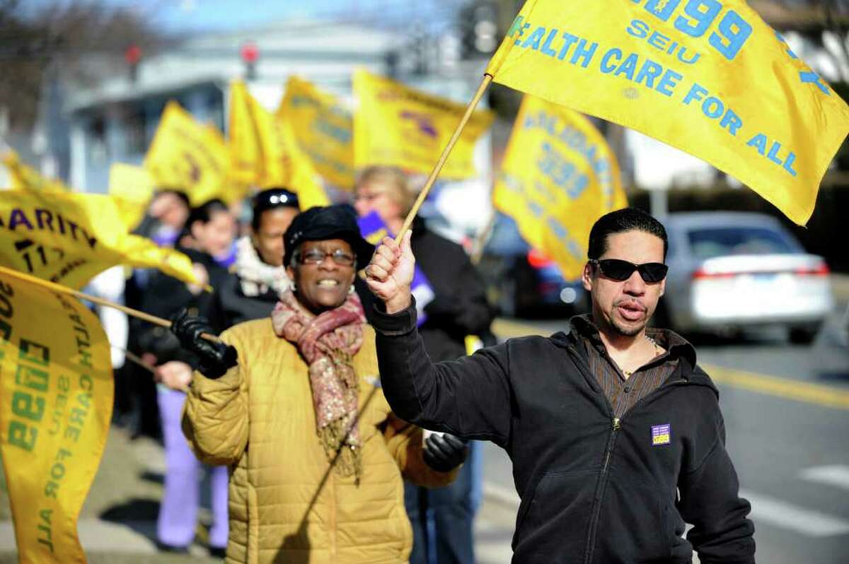 Nadine Ford, left, an LPN and Marcos Quiros, who works in housingkeeping, join the picket line with other workers at Danbury Health Care Center on Osborne Street Friday, March 9, 2012.