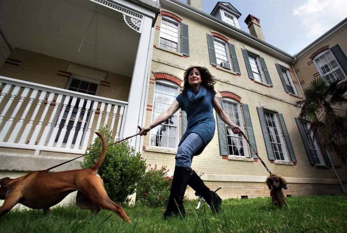 Carol Hirschi takes some of her rescued dogs for a walk in front of Mosheim Mansion, a bed-and-breakfast she operates in Seguin. She also runs a dog rescue at the same location.