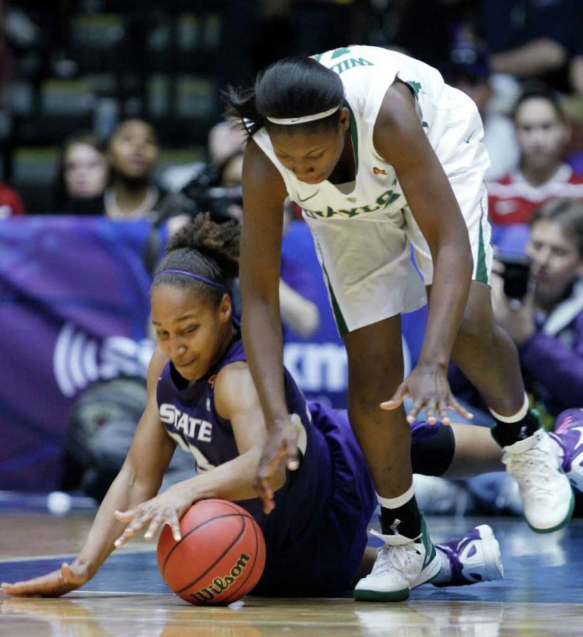 Kansas State forward Jalana Childs, left, and Baylor forward Destiny Williams battle for a loose ball in Friday's semifinals of the Big 12 women's tournament.