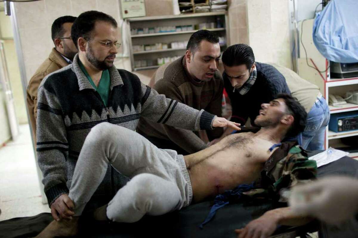 A Free Syrian Army fighters is attended by doctors after being injured during fighting against government troops in Idlib, north Syria, Saturday, March 10, 2012. U.N. envoy Kofi Annan met with Syrian President Bashar Assad on Saturday in Damascus during a high-profile international mission to mediate an end to the country's yearlong conflict. (AP Photo/Rodrigo Abd)