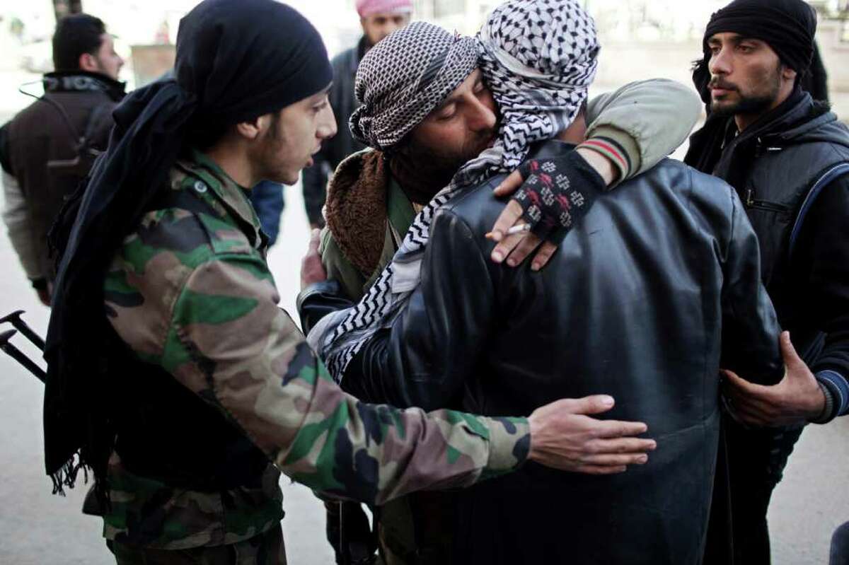 Free Syrian Army fighters console a comrade after an ambulance carried an injured friend to a hospital during fierce fighting against government troops in Idlib, north Syria, Saturday, March 10, 2012. U.N. envoy Kofi Annan met with Syrian President Bashar Assad on Saturday in Damascus during a high-profile international mission to mediate an end to the country's yearlong conflict. (AP Photo/Rodrigo Abd)