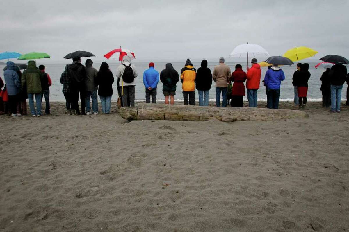 People gather for a memorial remembering the victims of the 2011 tsunami and nuclear disaster in Japan at Golden Gardens Park Beach in Seattle on Saturday, March 10, 2012. The vigil, which was organized by Artists for Japan, by included singing, silent prayer, and a drum performance by the Seattle Kokon Taiko group.