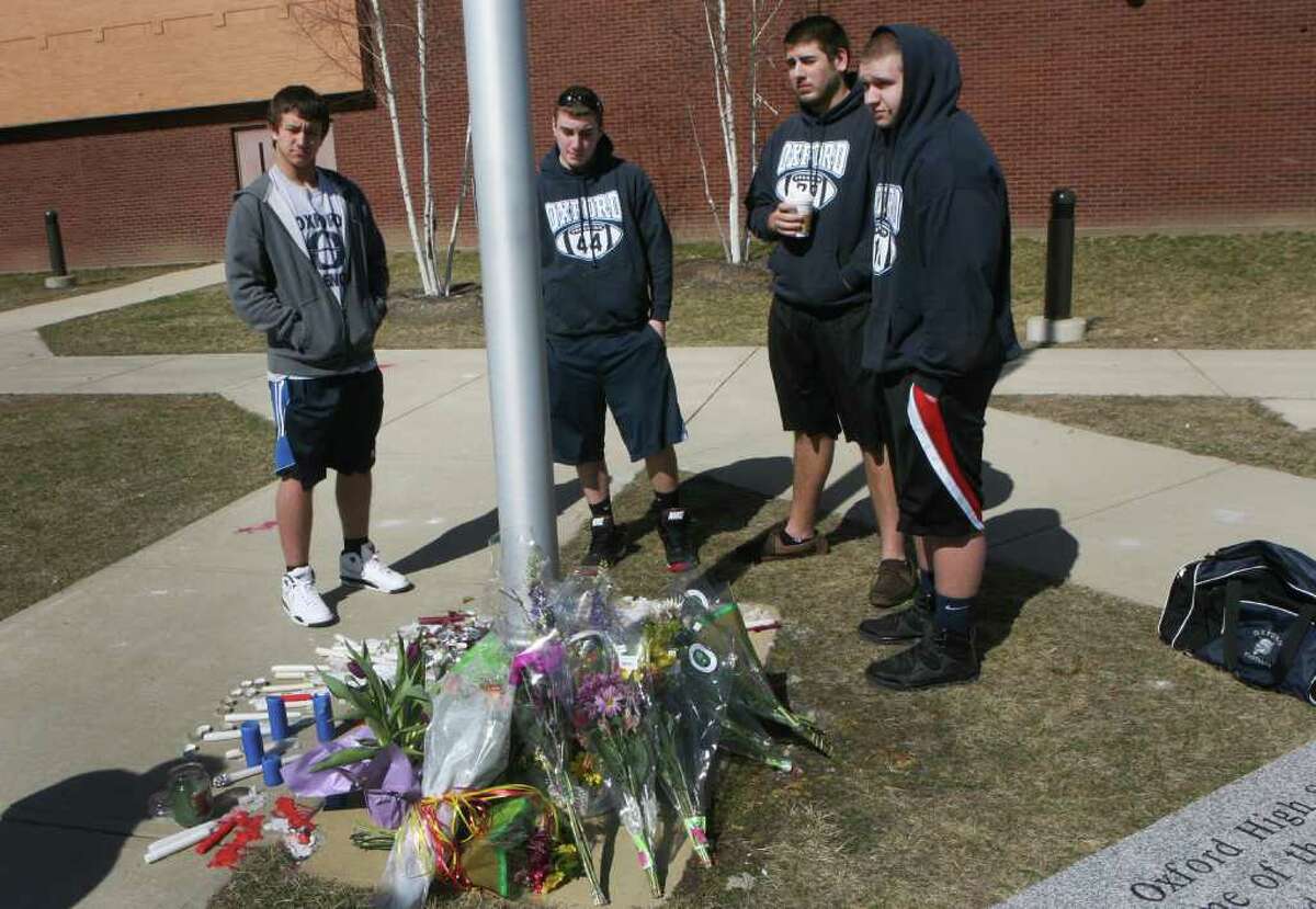 Fellow sophomores and football players, from left, Jeff Haney jr., Anthony Nichio, Justin Hanna, and Markus Esteves stand by a memorial at Oxford High School, which was created for their teammate Brandon Giordano, on Sunday, March 11, 2012. Giordano died in a car accident in Oxford, Conn. on Friday night.