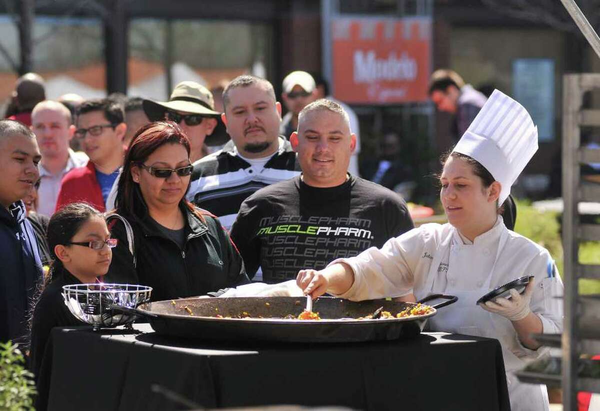 Julianna Glassaos cooks paella for a long line of waiting people during the Corona Paella Challenge at the Pearl Brewery Sunday.