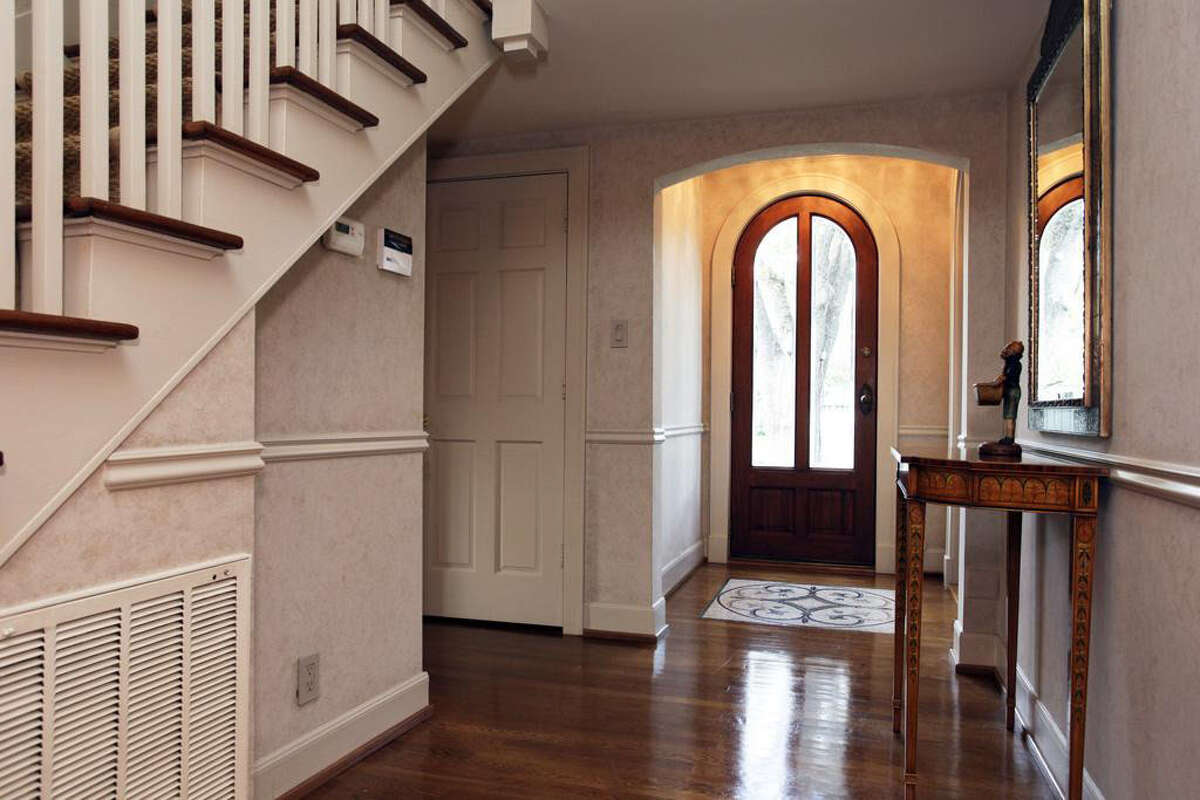 The entryway features hardwood floors, room for a foyer table, and close proximity to the second-floor stairway.