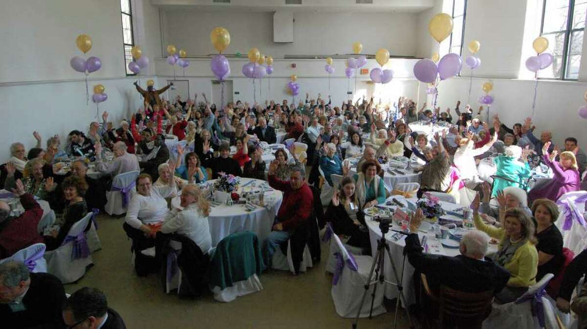 After helping themselves to a brunch buffet, residents of The Marvin and family members show their excitement that the organization reached its 15-year anniversary by throwing their hands in the air.