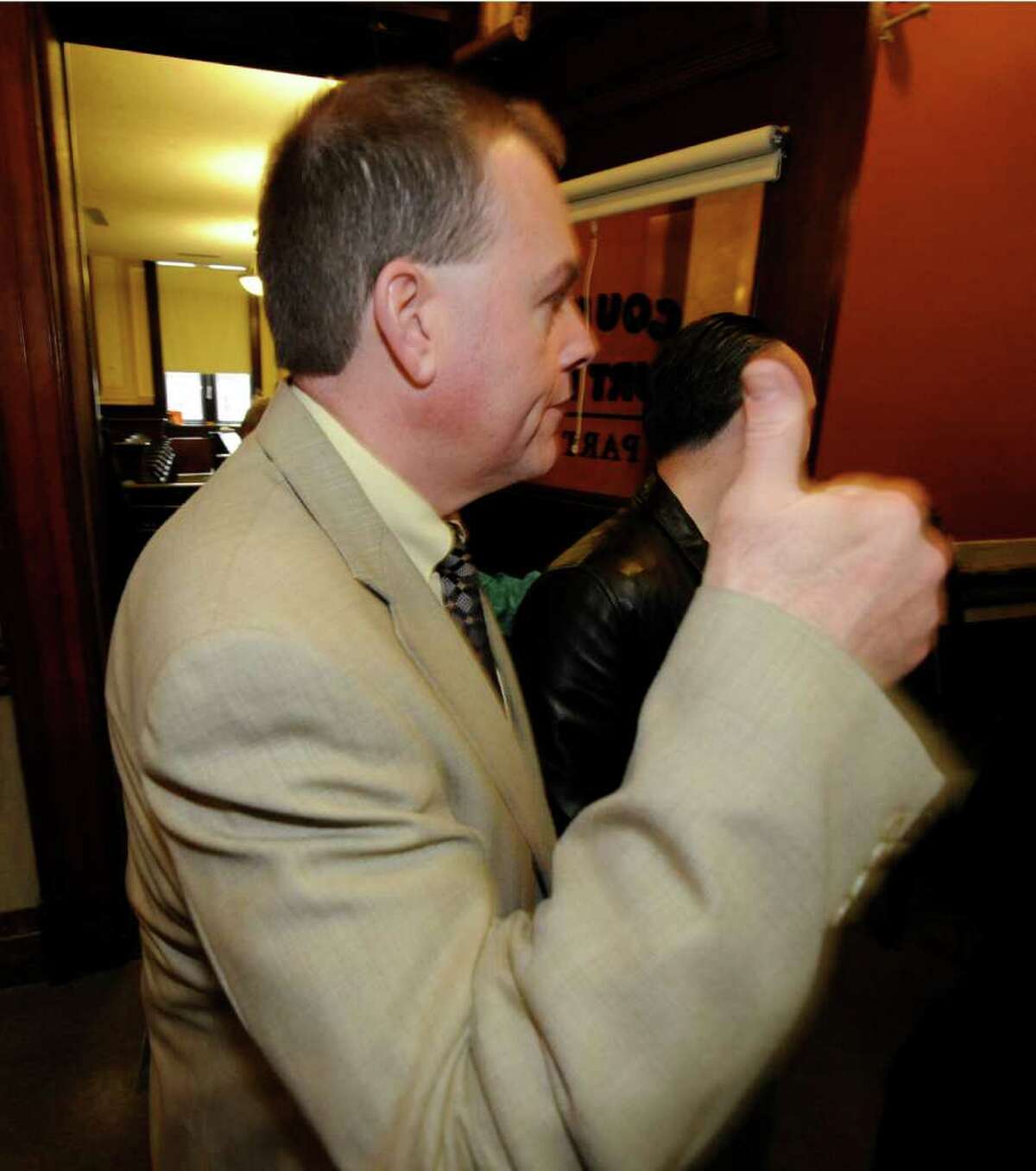 Edward McDonough gives the "thumbs up" sign as he leaves the courtroom after a hung jury caused Judge George Pulver to declare a mistrial in ballot fraud case in which he was a defendant in Troy, N.Y. March 13, 2012.