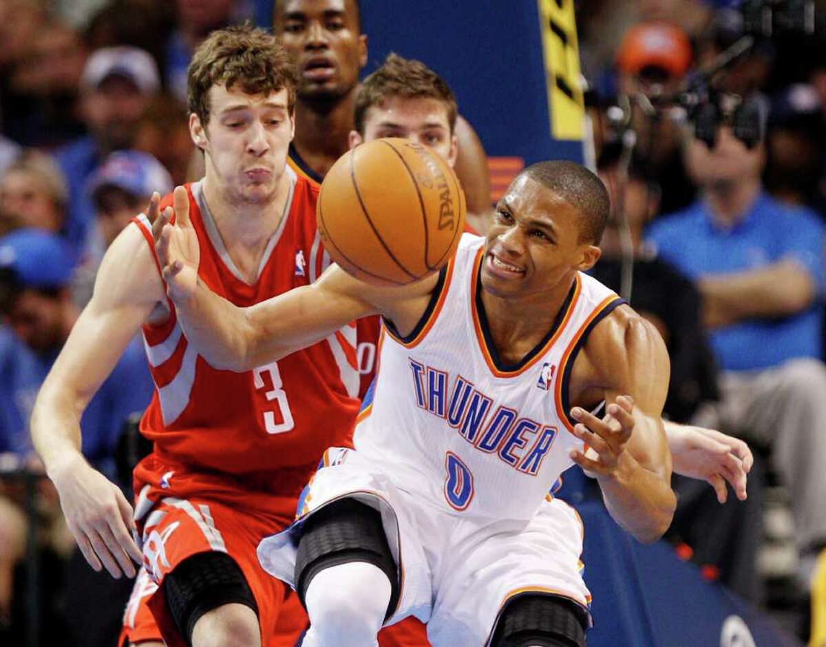 Oklahoma City Thunder guard Russell Westbrook (0) loses control of the ball as he is fouled by Houston Rockets guard Goran Dragic, left, of Slovenia, in the second quarter of an NBA basketball game in Oklahoma City, Tuesday, March 13, 2012. (AP Photo/Sue Ogrocki)