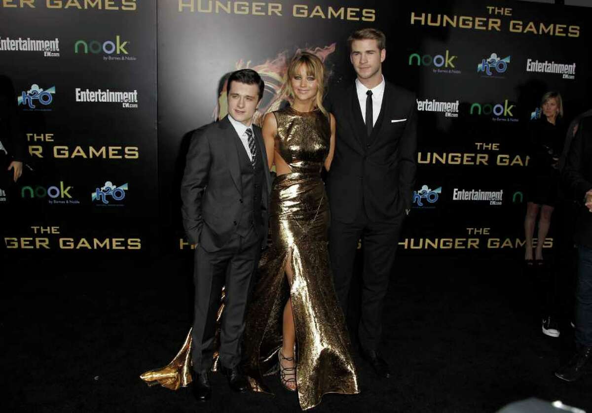Josh Hutcherson, left, Jennifer Lawrence and Liam Hemsworth arrive at the world premiere of "The Hunger Games" on Monday.