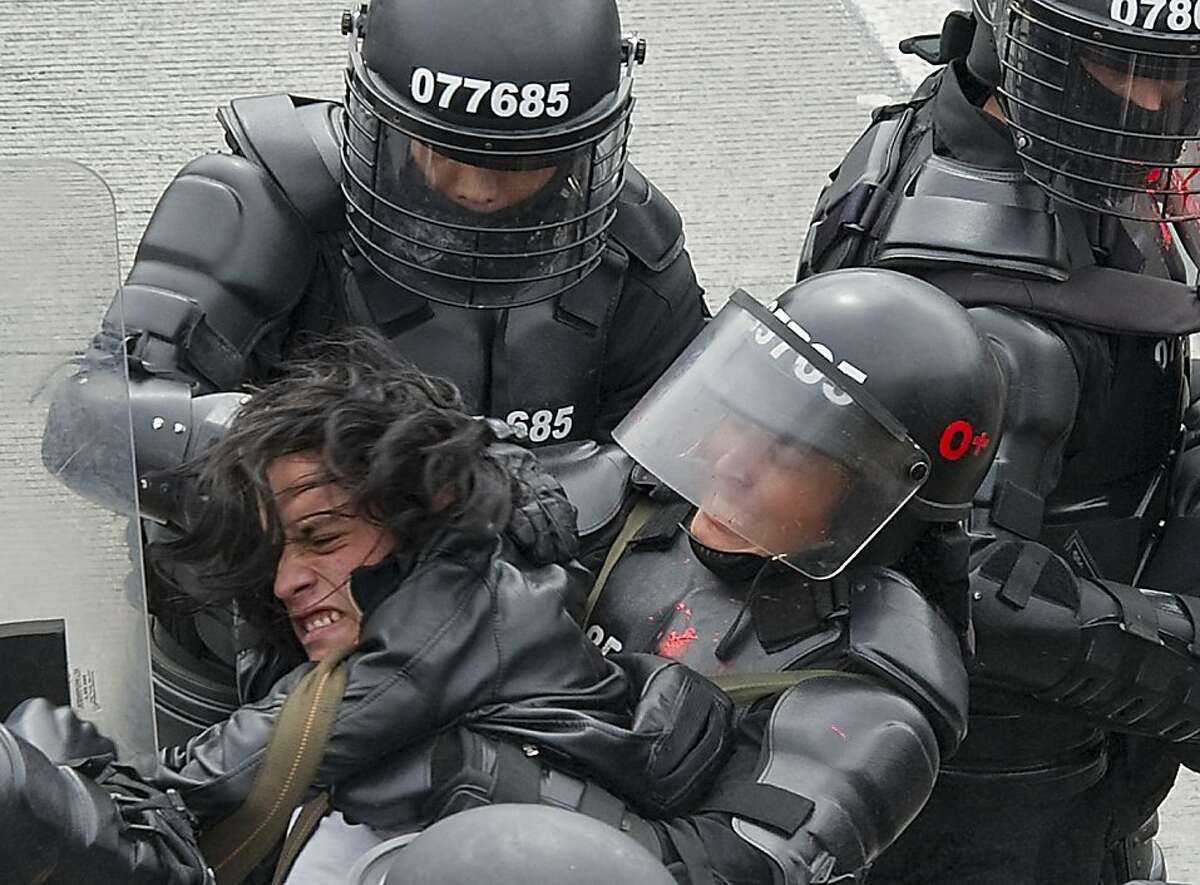 A student protesting against the high price and bad service offered by the Transmilenio public transport system, is arrested by the riot police, in Bogota, on March 9, 2012. TOPSHOTS/AFP PHOTO/Luis Acosta (Photo credit should read LUIS ACOSTA/AFP/Getty Images)