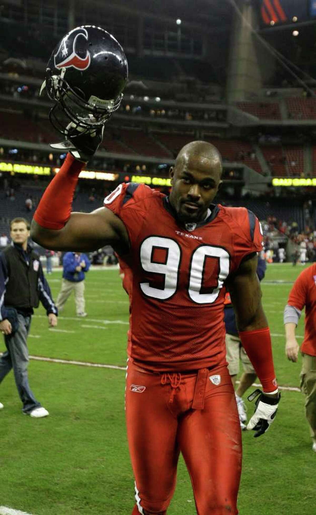 Houston Texans defensive end Mario Williams (90) raises his helmet to the crowd as he walks off the field after the Texans beat the Denver Broncos in an NFL football game at Reliant Stadium Thursday, Dec. 13, 2007, in Houston. The Texans defeated the Broncos 31-13. ( Brett Coomer / Chronicle )