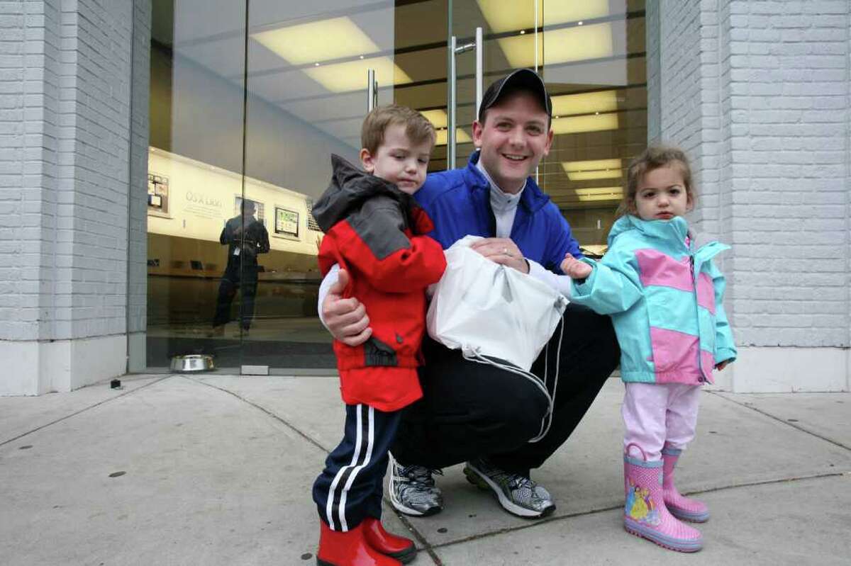 Michael Yardis of Greenwich and his two children Michael and Lily leave the Greenwich Avenue Apple store with one of the new Apple iPads Friday, March 16, 2012.