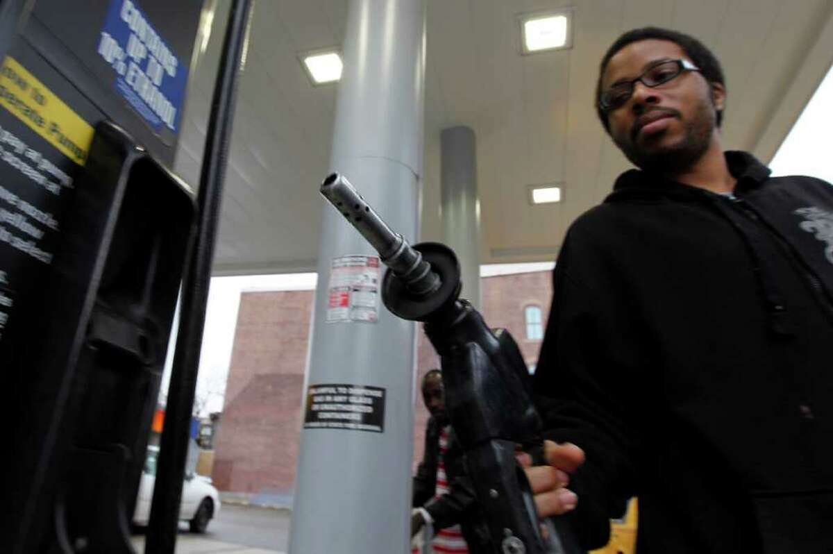 In this Feb. 24, 2012 photo, Michael Morris replaces the nozzle after putting gas in his car, in Philadelphia. A sharp jump in gas prices drove a measure of US consumer costs up in February. But outside higher pump prices, inflation stayed mild.