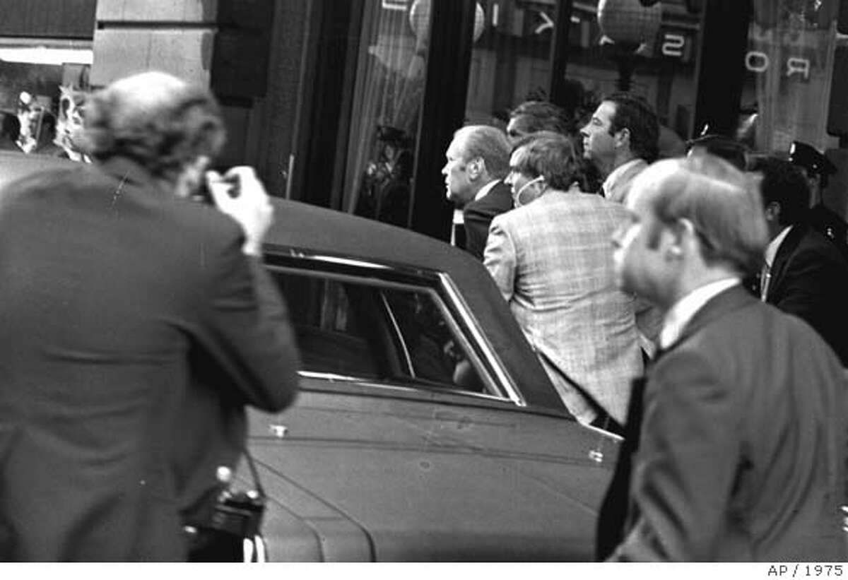 *** FILE *** President Ford ducks behind his limousine and is hustled into the vehicle after a shot was fired as he left the St. Francis Hotel in San Francisco, September 22, 1975. The President was rushed to the airport to return to Washington. Gerald R. Ford, who picked up the pieces of Richard Nixon's scandal-shattered White House as the 38th and only unelected president in America's history, has died, his wife, Betty, said Tuesday Dec. 26, 2006. He was 93. (AP Photo)