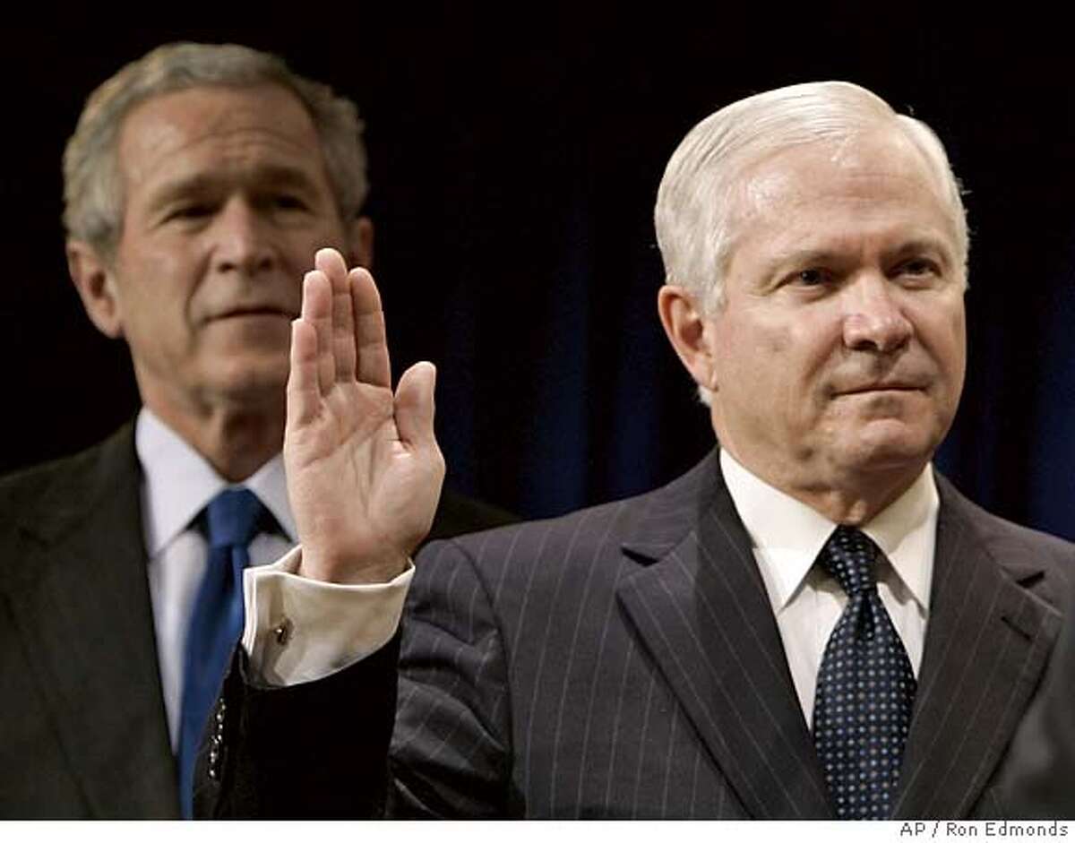 President Bush, left, watches as Defense Secretary Robert Gates is sworn in by Vice President Dick Cheney, not shown, during a ceremony at the Pentagon, Monday, Dec. 18, 2006. (AP Photo/Ron Edmonds)