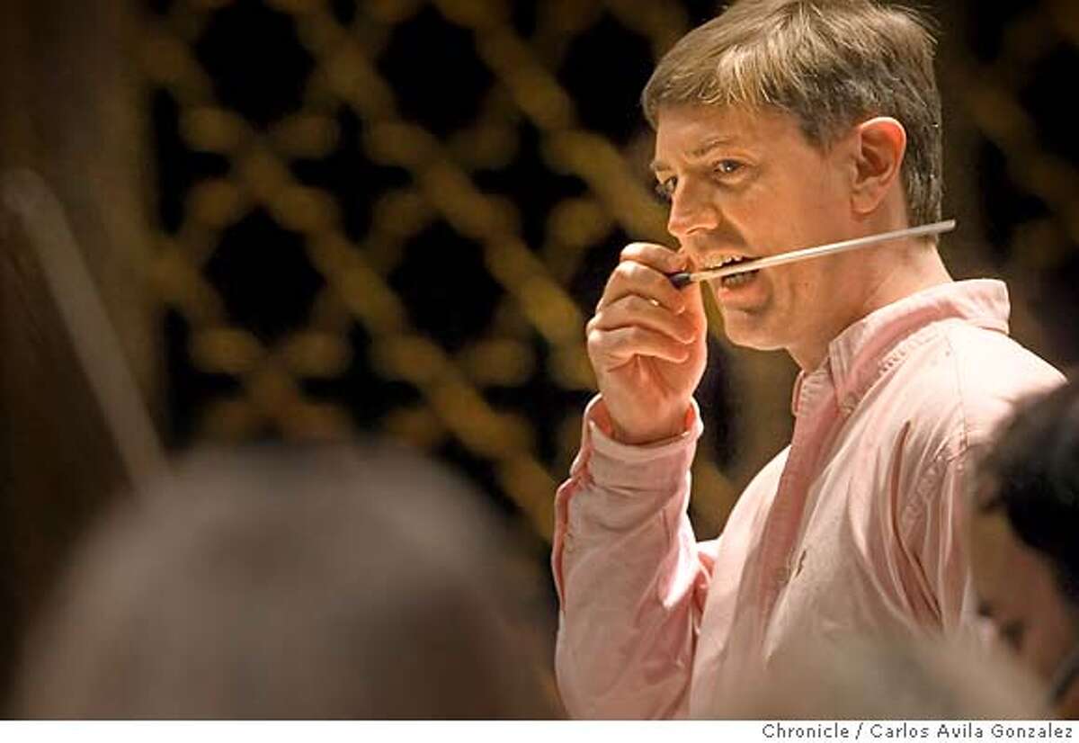 SILICONSYMPH03_014_CAG.CR2 Guest conductor, Martin West bites his baton when something goes awry during rehearsal with the Symphony Silicon Valley at the California Theater in San Jose, Ca., on Wednesday, October 25, 2006. The Symphony Silicon Valley is celebrating it's 4th year in business -- and it's 5th artistic season -- after a major reorganization (the old San Jose Symphony went bankrupt). The symphony does not have a permanent conductor, and operates by having a guest conductor for each of the 7 programs it puts on each year. We shoot guest conductor Martin West and guest cellist Gary Hoffman -- one of the world's top cellists, a rival of YoYo Ma's -- in action with the orchestra. Photo by Carlos Avila Gonzalez/The San Francisco Chronicle Photo taken on 10/25/06, in San Jose, Ca, USA **All names cq (source) Ran on: 12-05-2006 Symphony Silicon Valley, in San Joses California Theatre, uses a different guest conductor for each program, including Martin West, below.