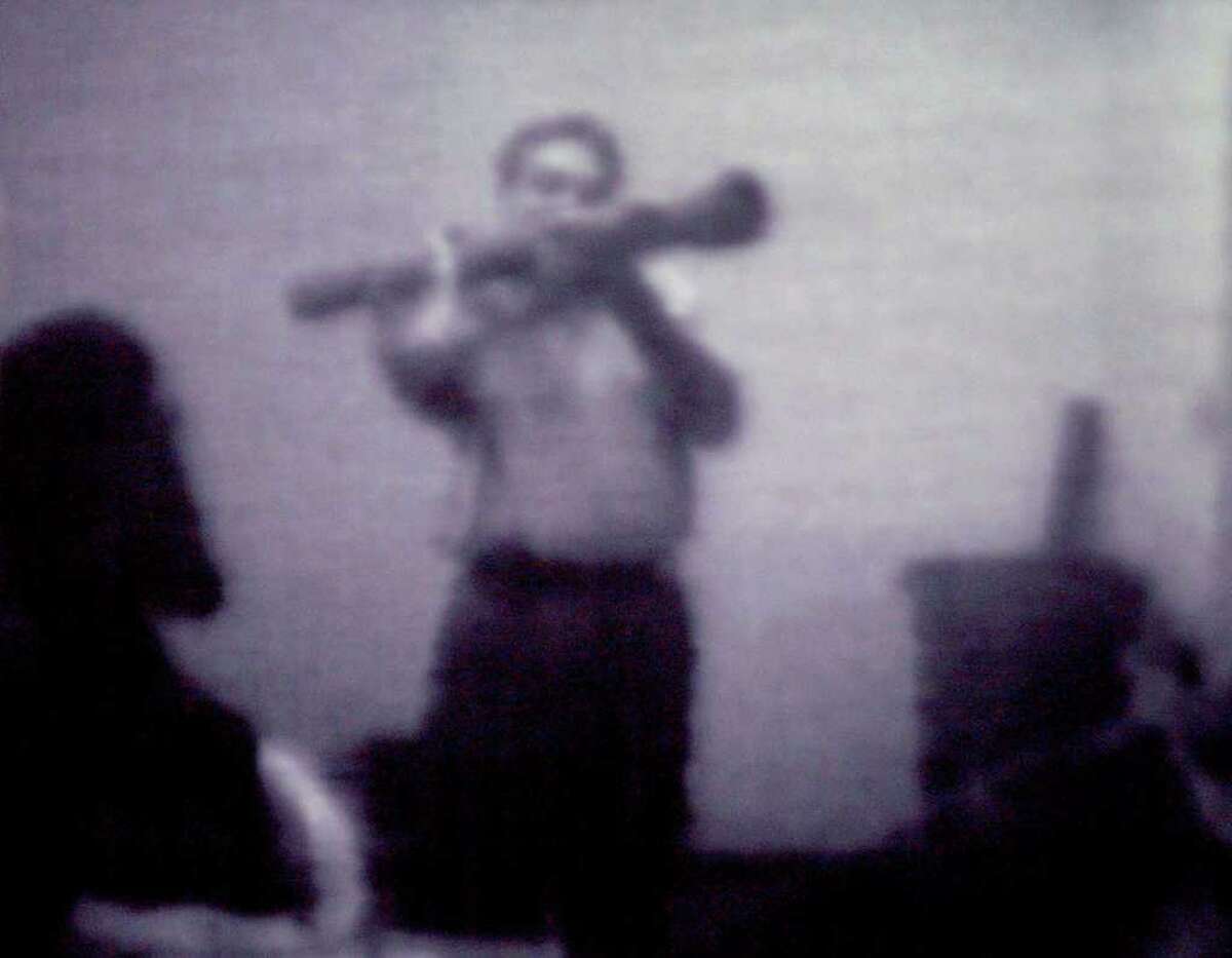 Still image from a surveillance videotape shows informant Shahed Hussain wielding an inert, inoperable shoulder-fired rocket launcher to suspects in a federal terrorism sting in Albany (Times Union archive)