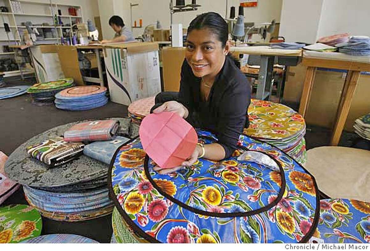 .jpg Welch, inside her shop, holds the original construction paper design that launched her business back in July of 2004. Parent entrepreneurs -- people who start businesses based on their experience raising their kids. This photo order is for a sider, a profile of Grace Welch, a Filipina-American who has built up a $400,000 online business manufacturing and selling her unique design of baby changing pads. Event in, San Francisco, Ca, on 11/17/06. Photo by: Michael Macor/ San Francisco Chronicle Mandatory credit for Photographer and San Francisco Chronicle / Magazines Out