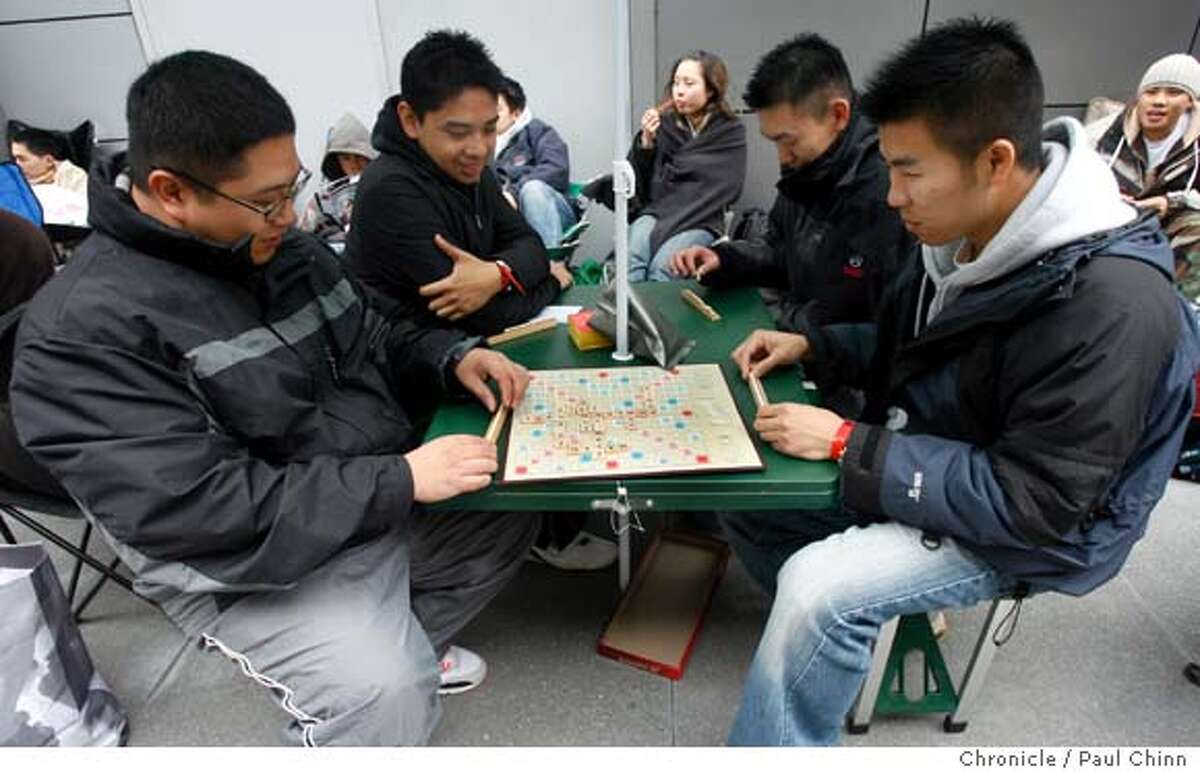 From left, David Giang, Chris Valiao, Vincent Chan and Eric Tong play an old-fashioned game of Scrabble while waiting in line to buy the next generation video game as enthusiasts wait in long lines to be the first to buy a Sony Playstation 3 video game console at Metreon in San Francisco, Calif. on Thursday, Nov. 16, 2006. About 500 units were to be made available for the diehards - some who arrived at 8 a.m. Wednesday. PAUL CHINN/The Chronicle **David Giang, Chris Valiao, Vincent Chan, Eric Tong