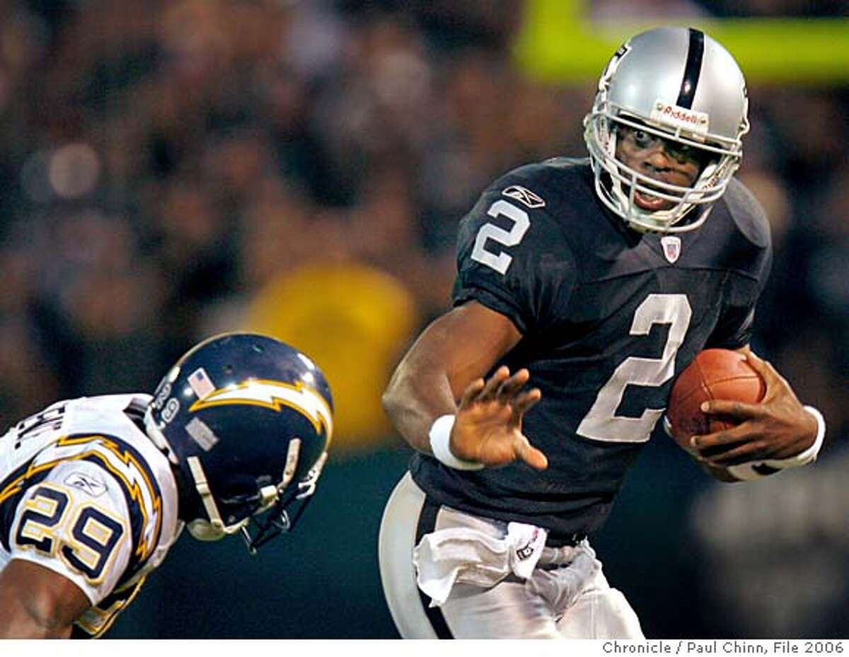 Quarterback Aaron Brooks keeps San Diego's Drayton Florence at arm's length in the second quarter of the Oakland Raiders vs. San Diego Chargers at McAfee Coliseum in Oakland, Calif. on Monday, September 11, 2006. PAUL CHINN/The Chronicle **Aaron Brooks, Drayton Florence