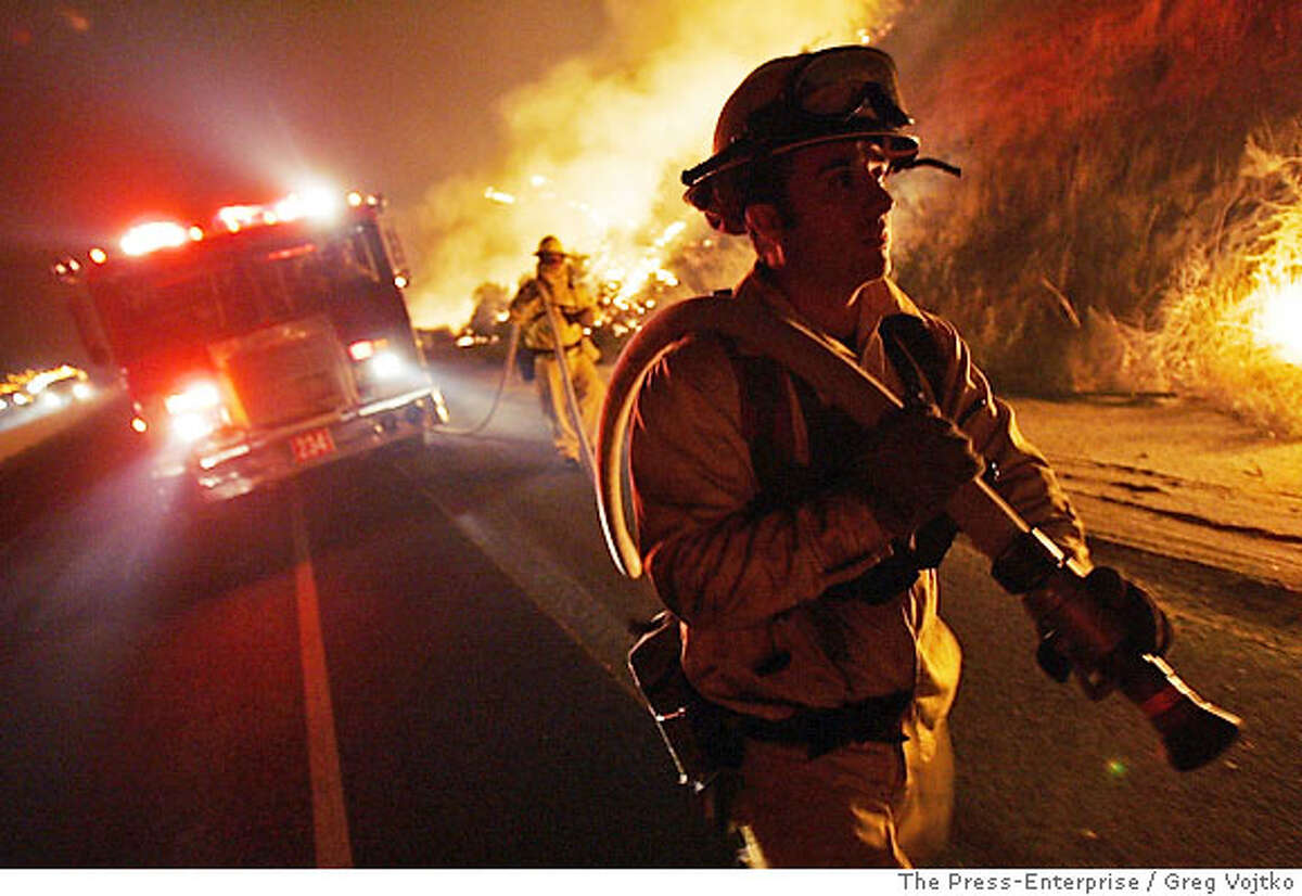 Firefighter Raymond De La Huerta keeps watch on backfires along Hwy 79/Lamb Canyon Road early Friday, Oct. 27, 2006, near Beaumont, Calif., as efforts to combat the Esperanza Fire continue. (AP Photo/The Press-Enterprise/Greg Vojtko) **MANDATORY CREDIT** , MAGS OUT.