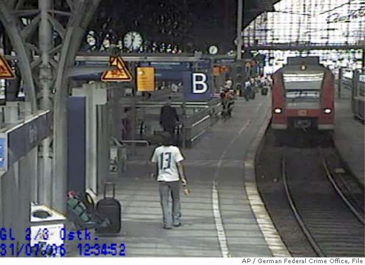 The picture taken by a surveillance camera released by German Federal Crime Office in Wiesbaden, western Germany, Friday, Aug 18, 2006, shows one of the two men, back to camera in forground, suspected of placing two bombs in two German regional trains on July 31, 2006. German investigators said Friday that two bombs found last month on regional trains had a "possible terrorist background," but were cautious about drawing conclusions from material with Arabic script found with the devices. The bombs, made with gas canisters, were found July 31 on trains in Dortmund and Koblenz. Joerg Ziercke, the head of Germany's Federal Crime Office, said they apparently were supposed to explode 10 minutes before the trains' arrival at the stations. (AP Photo/German Federal Crime Office)