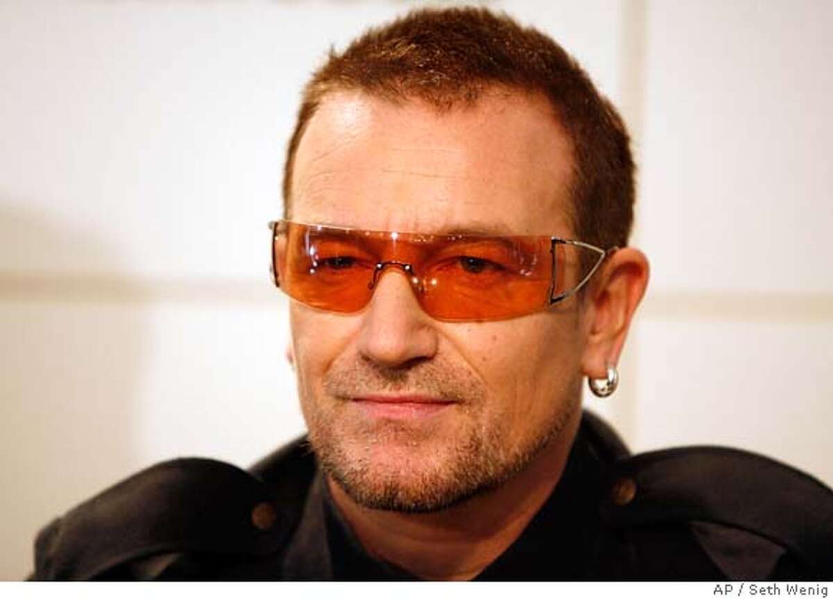 Bono of the band U2 signs copies of the new book "U2 by U2" Tuesday, Sept. 26, 2006 in New York. (AP Photo/Seth Wenig)