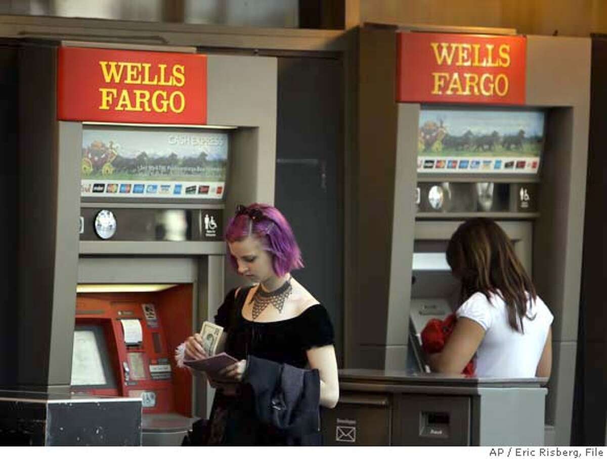 A woman puts away her money after visiting a Wells Fargo automated teller machine in San Francisco, Monday July 17, 2006. Wells Fargo & Co., the nation's fifth largest bank, reports record profits in the second quarter, but the results are a penny shy of Wall Street's expectations. (AP Photo/Eric Risberg) Ran on: 07-19-2006 Wells Fargo ATMs are ubiquitous in San Francisco and a steady fee generator.