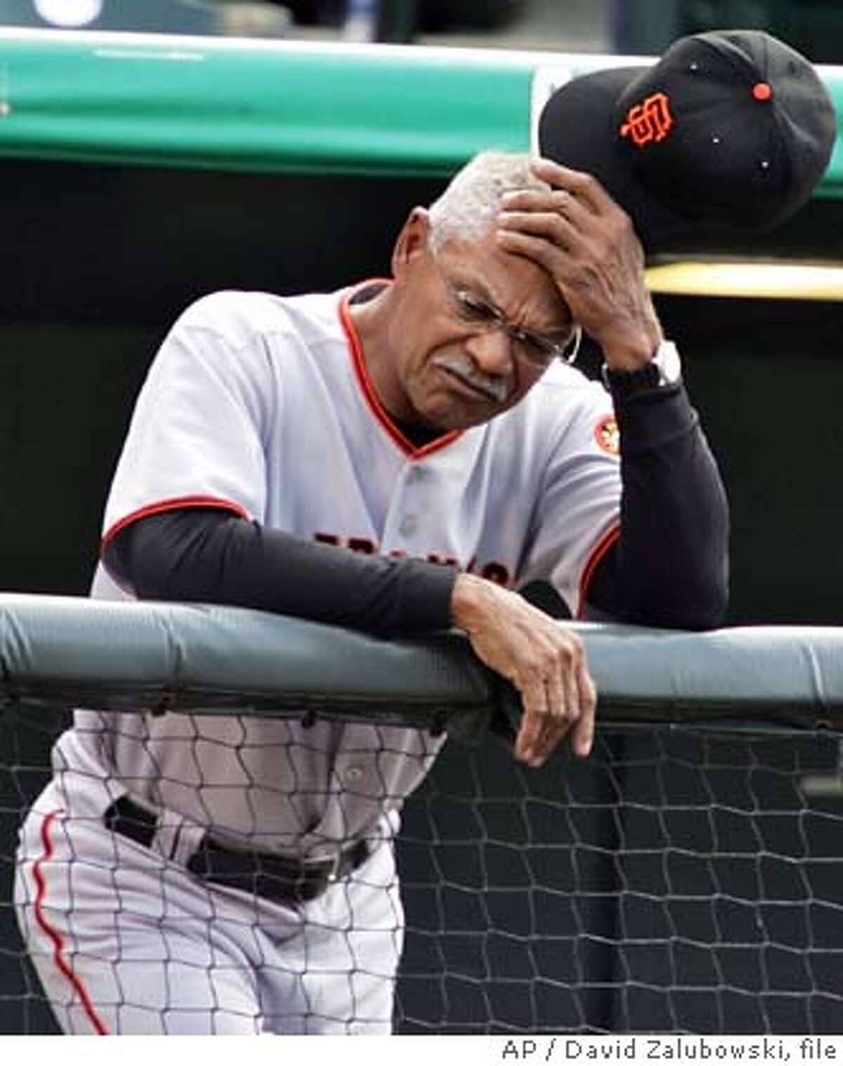 ** FILE ** San Francisco Giants manager Felipe Alou holds his head as he leans over the rail while looking on as pitcher Brad Hennessey falls behind in the count to Colorado Rockies' Todd Helton in a baseball game in Denver on May 18, 2005. Alou plans to fly home to Florida and then the Dominican Republic as soon as the season ends, even if his future with the Giants has yet to be resolved. (AP Photo/David Zalubowski, file)