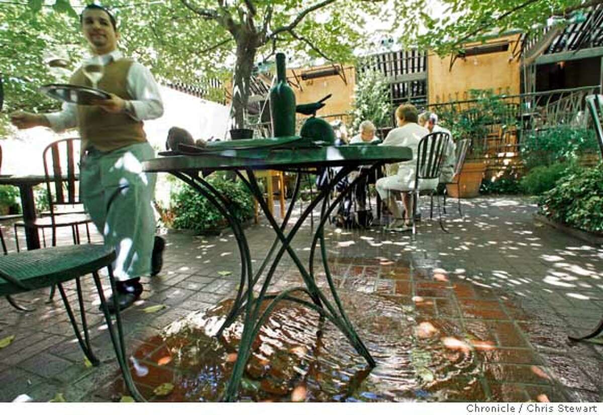 A water feature is designed as a cafe table in the outdoor patio of Ristorante Tra Vigne in St. Helena.