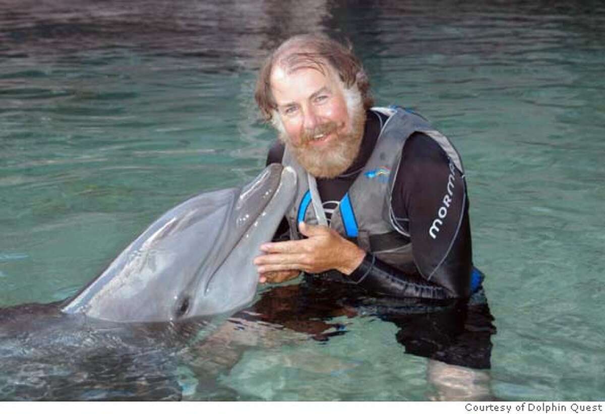 Lono, a bottlenose dolphin, nuzzles the Chronicle�s Tom Stienstra. Photo: Courtesy of Dolphin Quest