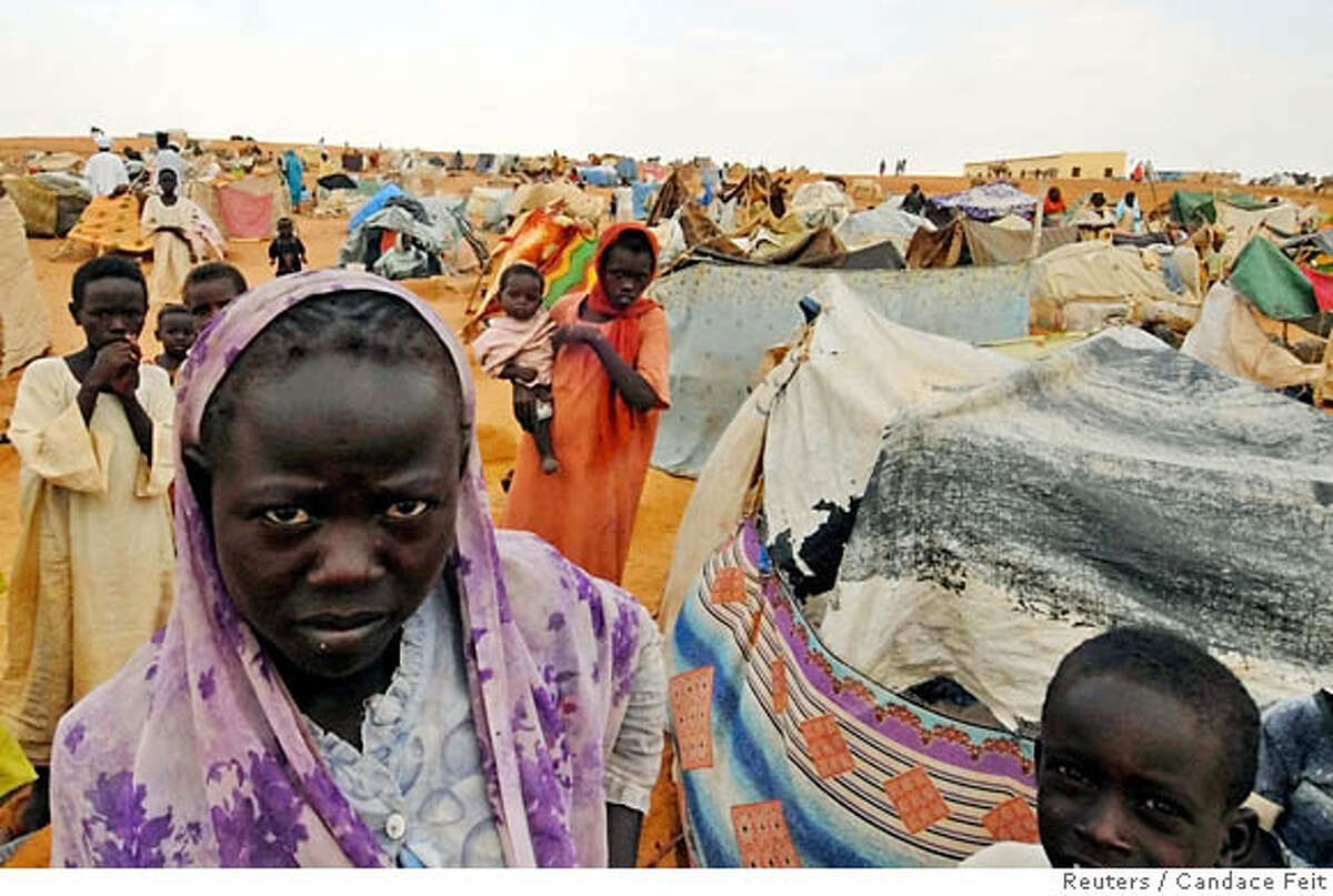 A young girl stands in front of new makeshift shelters for people who arrive at Abu Shook camp in El Fasher, nothern Darfur August 26, 2006. As pressure mounts on Sudan to accept U.N. troops in its violent Darfur region, the Khartoum government is closing ranks in defiance, raising fears of a deadlock that could hasten Darfur's descent into chaos. Picture taken August 26, 2006. REUTERS/Candace Feit (SUDAN) 0