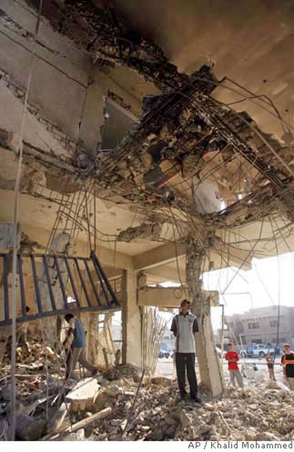 A resident views a big hole in the ceiling of his building following a bomb blast inside one of the apartments on Thursday, in Baghdad, Iraq, Friday Sept. 1, 2006. A barrage of coordinated bomb and rocket attacks on Aug. 31, 2006, across eastern Baghdad neighborhoods killed at least 55 people and wounded more than 200 within about half an hour, police said Friday.The attacks on mainly Shiite neighborhoods came even as Prime Minister Nouri al-Maliki said Iraqi forces should have control over most of the country by year's end. (AP Photo/Khalid Mohammed)