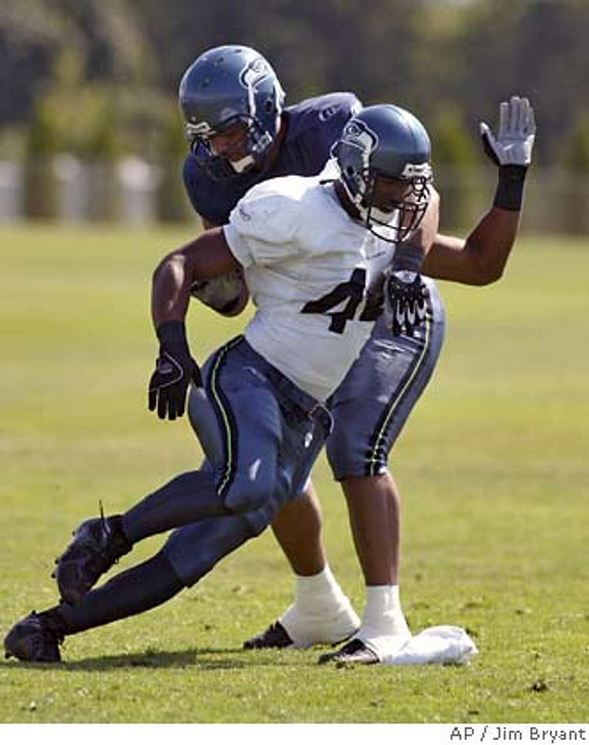 Seattle Seahawks linebacker Julian Peterson, front, gets by offensive tackle Sean Locklear in pass protection drills during football training camp Tuesday Aug. 1, 2006, at Eastern Washington University in Cheney, Wash. (AP Photo/Jim Bryant) EFE OUT