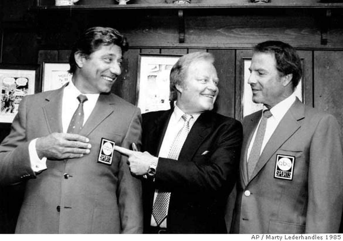 ** FILE ** Joe Namath, left, Roone Arledge, center, pointing to Namath's sports coat logo, and Frank Gifford pose at a news conference at the "21 Club in New York after announcing that Namath will join the crew of "Monday Night Football, " in this July 9, 1985 photo. Arledge, a pioneering television executive at ABC News and Sports responsible for creating shows from ``Monday Night Football'' to ``Nightline,'' died Thursday, Dec. 5, 2002 at Memorial Sloan-Kettering Cancer Center in New York, an ABC News spokesman said. He was 71." (AP Photo/Marty Lederhandler) CAT A July 9, 1985 file photo