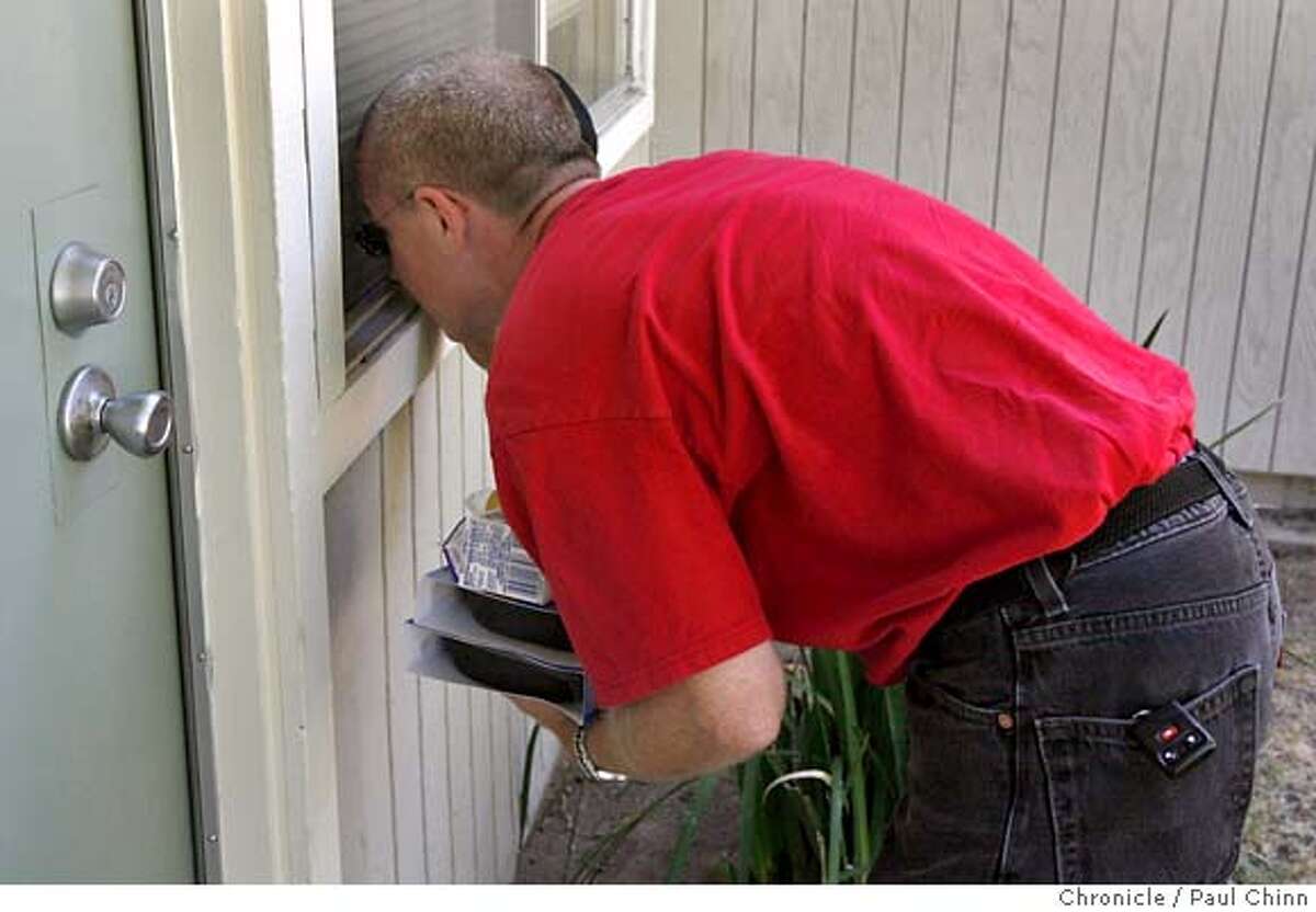 Doug Lilly, who delivers food to the elderly for The Salvation Army, peeks through a window to make sure his client - who didn't answer the door - wasn't lying on the floor from heat stroke in Modesto, Calif. on Wednesday, July 26, 2006. The client wasn't at home. Lilly has yet to find anyone dead while on his rounds but dreads the day that it happens. Residents continued to cope with the blazing heat in this Central Valley city which experienced another day of triple-digit temperatures. PAUL CHINN/The Chronicle **Doug Lilly