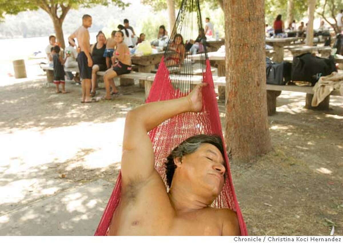 At Del Valle Regional Park, in Livermore, Alfonso Torres (cq) of San Jose, takes refuge from the heat in his hammock that he says he brings everywhere. The steady 111 degree weather drove people to find shade and to the beach at Del Valle Regional Park in Livermore..(CHRISTINA KOCI HERNANDEZ/THE CHRONICLE) *Alfonso Torres Mandatory Credit For Photographer and San Francisco Chronicle/No-Sales-Mags Out