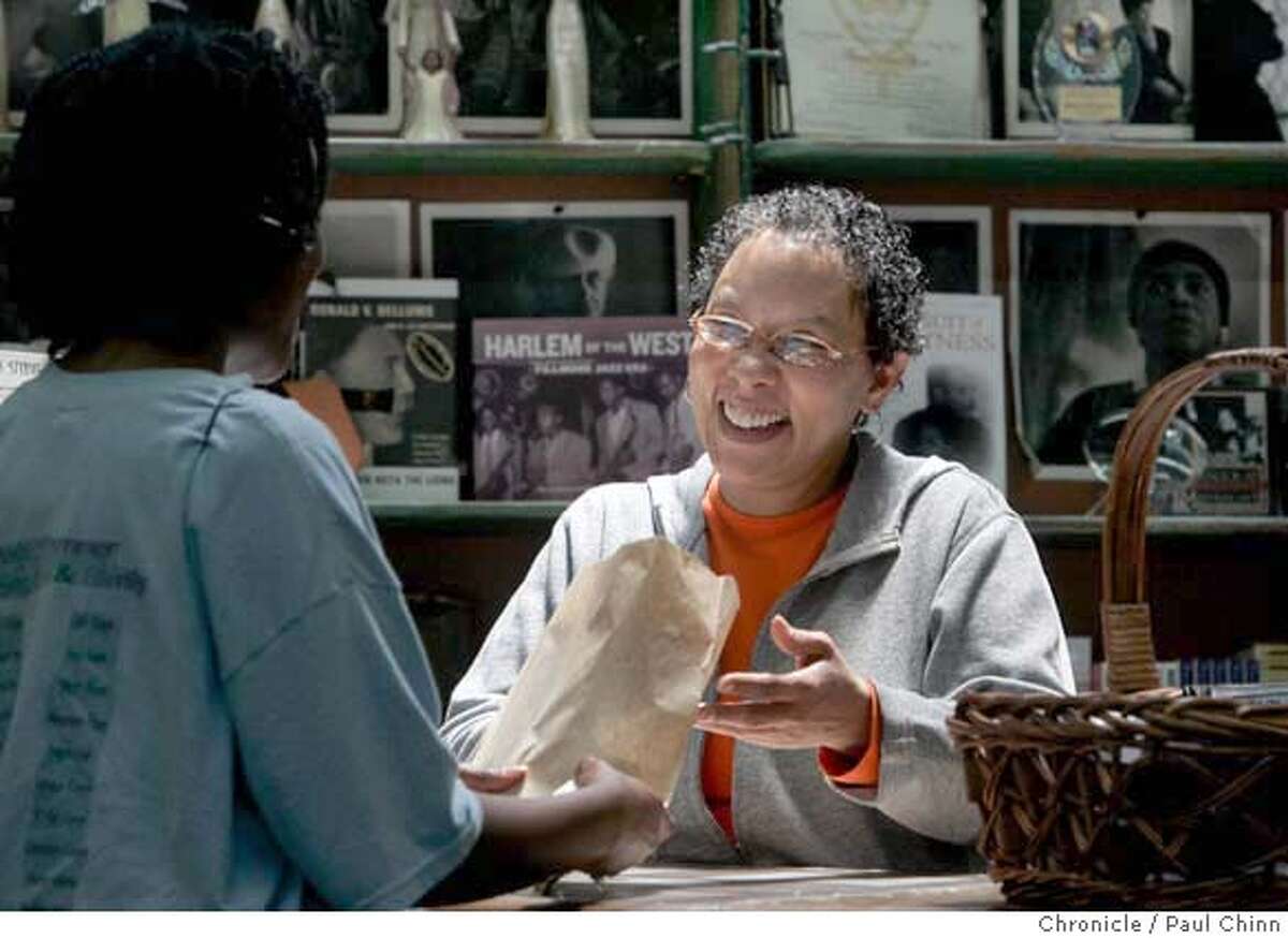 Marcus Books owner Blanche Richardson helps long-time customer Latanya Tigner (left) at the shop in Oakland, Calif. on Tuesday, July 18, 2006. The family-owned bookstore, in business for the past 46-years, will soon be launching a website for limited online orders and is considering opening a cafe to compete with Amazon.com and chain store book retailers. PAUL CHINN/The Chronicle **Blanche Richardson, Latanya Tigner MANDATORY CREDIT FOR PHOTOGRAPHER AND S.F. CHRONICLE/ - MAGS OUT