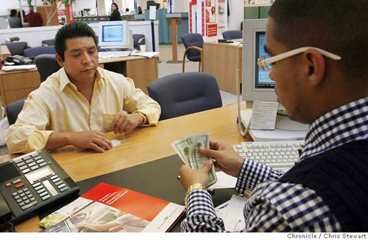 Event on 7/13/06 in San Francisco. New bank customer Roberto Hernandez, 44, (left) is helped by Winston Mendoza, 25, a small business specialist for Bank of America, 2701 Mission Street, SF, as he opens a checking account that includes B of A's free SafeSend money transfer service. The service allows the free sending and receiving of money to Mexico. Chris Stewart / The Chronicle MANDATORY CREDIT FOR PHOTOG AND SF CHRONICLE/ -MAGS OUT