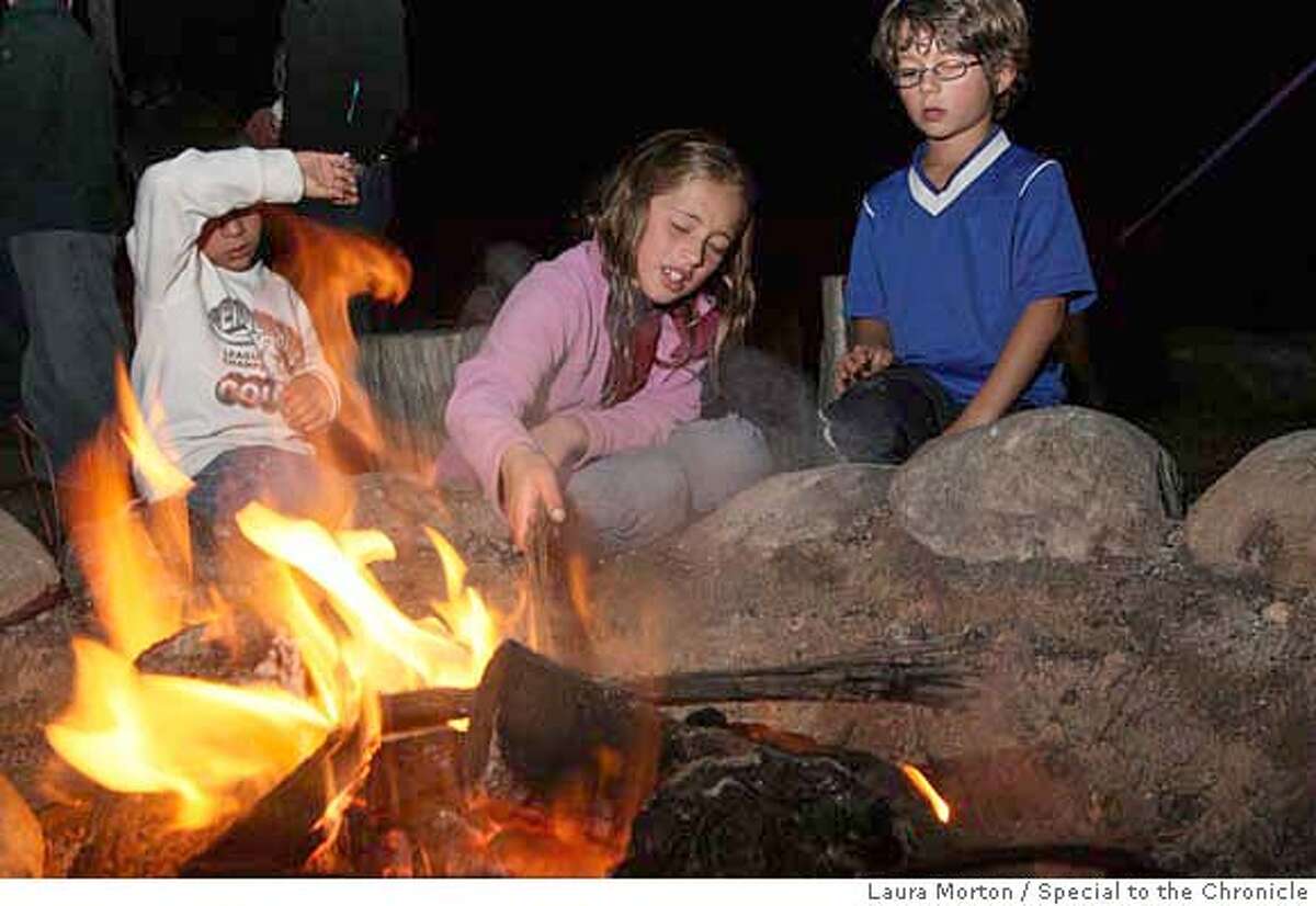 PARKS_KIDS22_0101_LKM.jpg Jordan Pineda, 9, (center) and Ellis Webb (right) play with the fire during a family campfire program at Rob Hill Campground in the Presidio. The campfire, organized by the Crissy Field Center, offered families a chance to make s'mores, listen to stories from park rangers and sing campfire songs. (Laura Morton/Special to the Chronicle) *** Jordan Pineda *** Ellis Webb