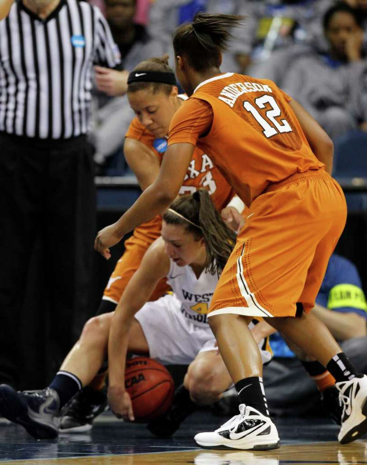 West Virginia guard Brooke Hampton (4) tries to guard the ball as Texas guard Yvonne Anderson (12) and Ashleigh Fontenette (33) close in during the first half of a first-round NCAA tournament women's college basketball game in Norfolk, Va., Saturday, March 17, 2012. (AP Photo/Steve Helber)