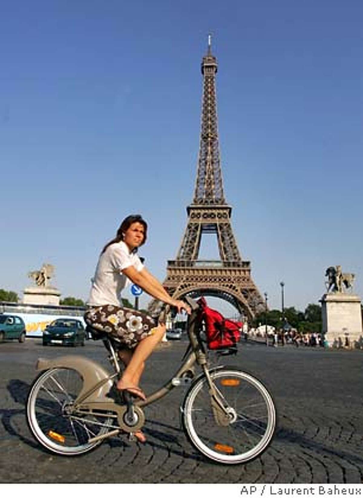 A rider uses a new bicycle provided by Paris City Hall, around the Eiffel Tower in Paris, Sunday, July 15, 2007. Paris City Hall launched a new bicycle service Sunday, with more than 10,600 posted at 750 stations all over the city and prices starting at a euro (US$1.36) for a one-day pass. Users can take a bike and put it back at any station around town. (AP Photo/Laurent Baheux)