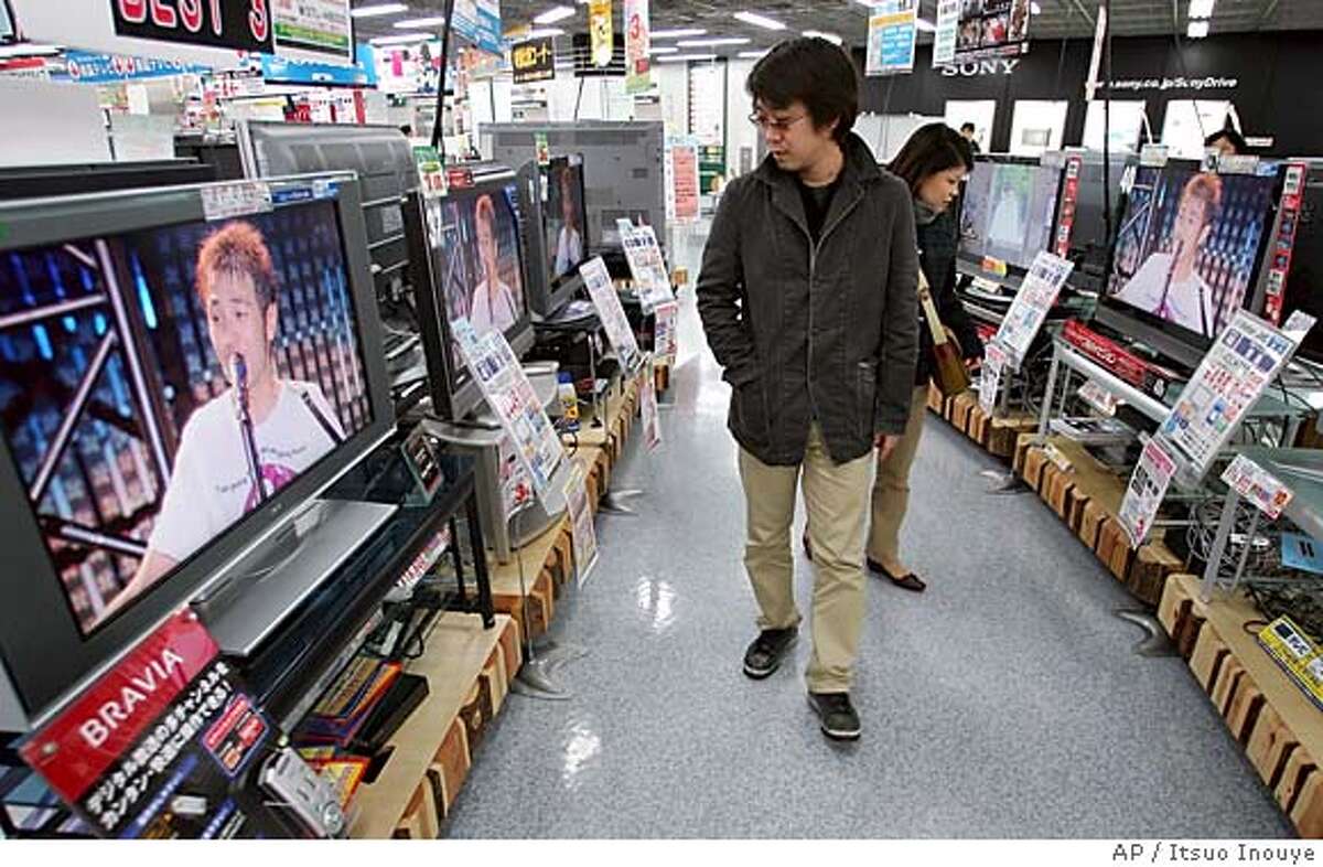 A couple checks flat panel TVs at retail chain Yodobashi Camera Co. store in Tokyo's Akihabara electronics district Wednesday, Feb. 22, 2006. Just five years ago, Japan's electronics makers were stuck in the doldrums, battered by competition from cheaper Asian rivals as prices for computer chips and gadgets nose-dived. These days, they're enjoying far brighter times. The key to the gradual turnaround at big Japan Inc. names like Panasonic, Sharp and Sony lies in one booming product: TVs. (AP Photo/Itsuo Inouye)