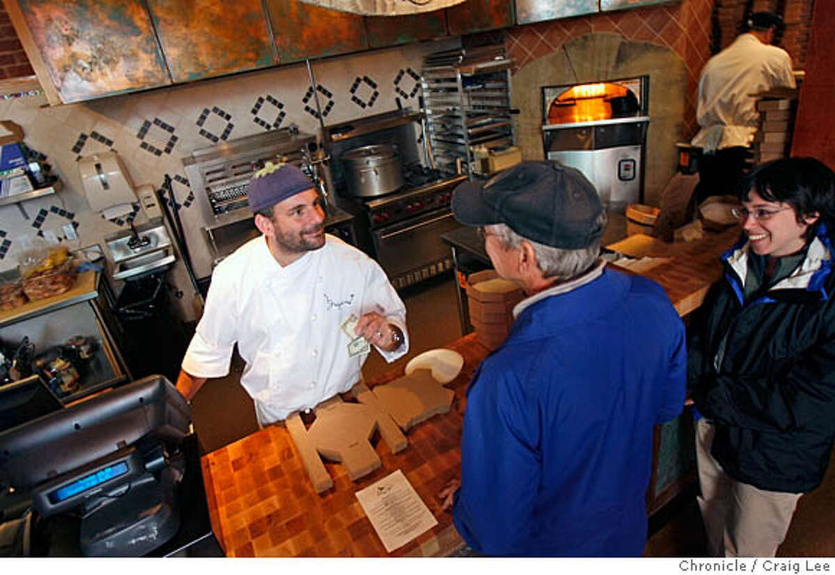 FOODMALL05_085_cl.JPG Photo of new food malls in the Bay Area. This is Epicurious Garden at 1509 Shattuck in Berkeley. Photo of Gregoire Jacquet, chef and owner of Socca Oven, taking an order from Kevin Sutton and his daughter, Rebecca Sutton. Craig Lee / The Chronicle MANDATORY CREDIT FOR PHOTOG AND SF CHRONICLE/ -MAGS OUT